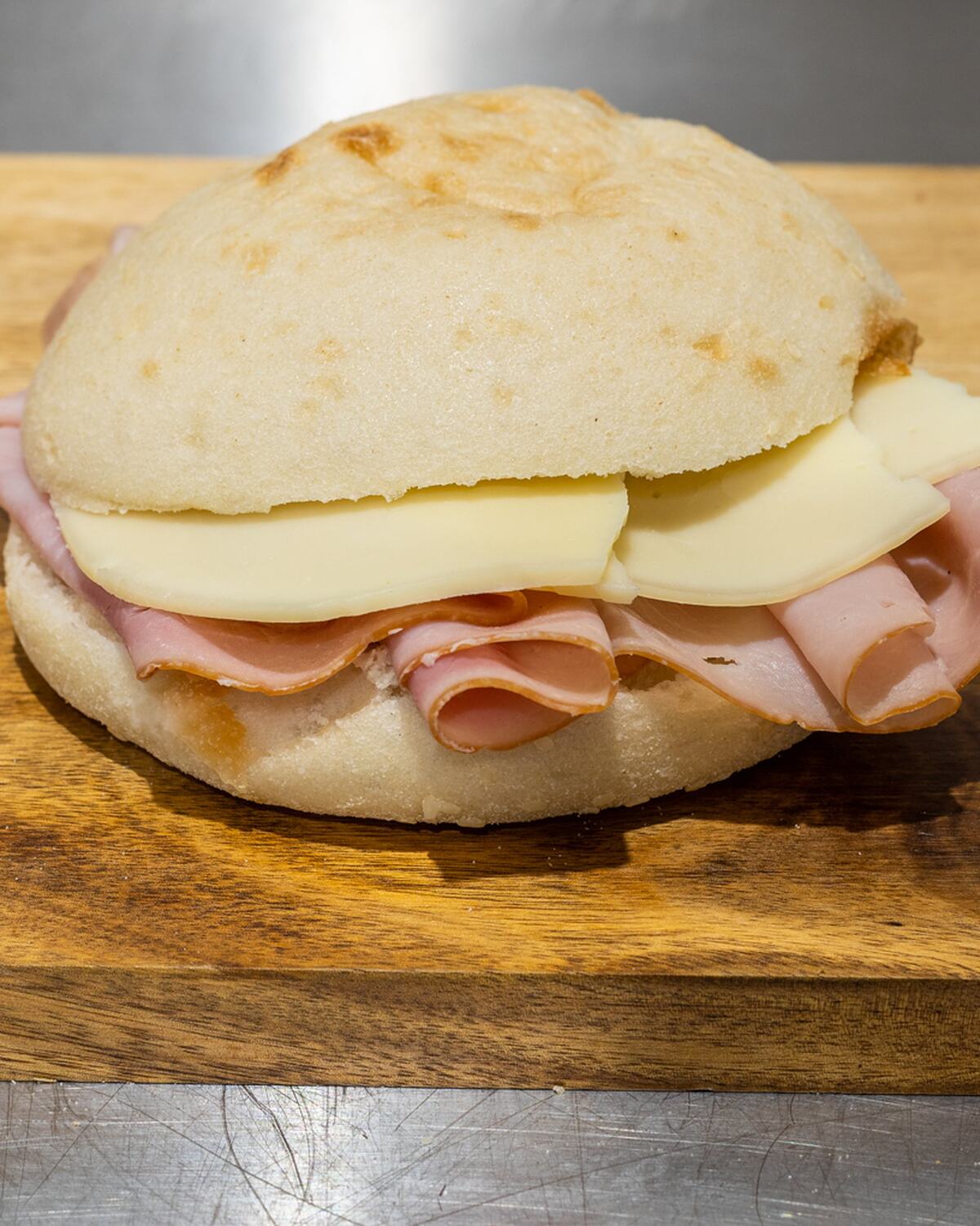 A ham and provolone roll from Rose's Deli on the wooden counter